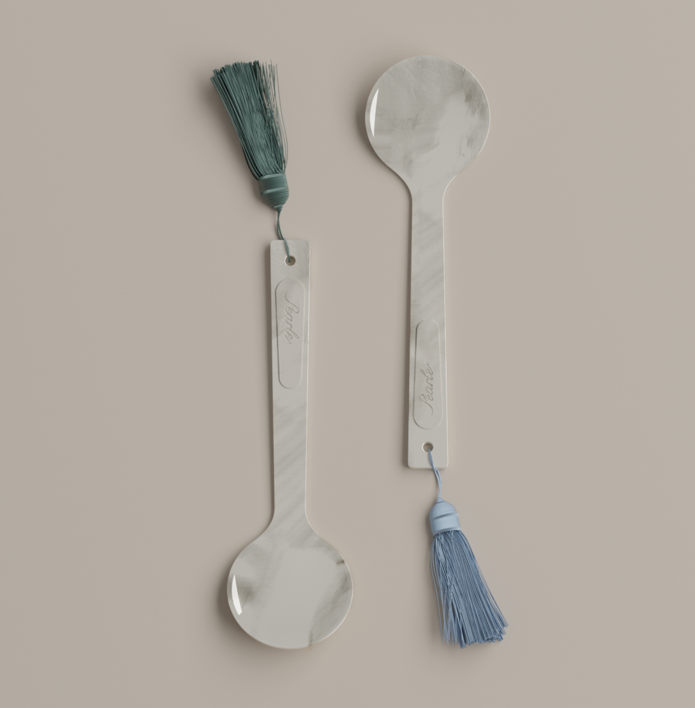 Two mother of pearl caviar spoons with tassels on a beige background