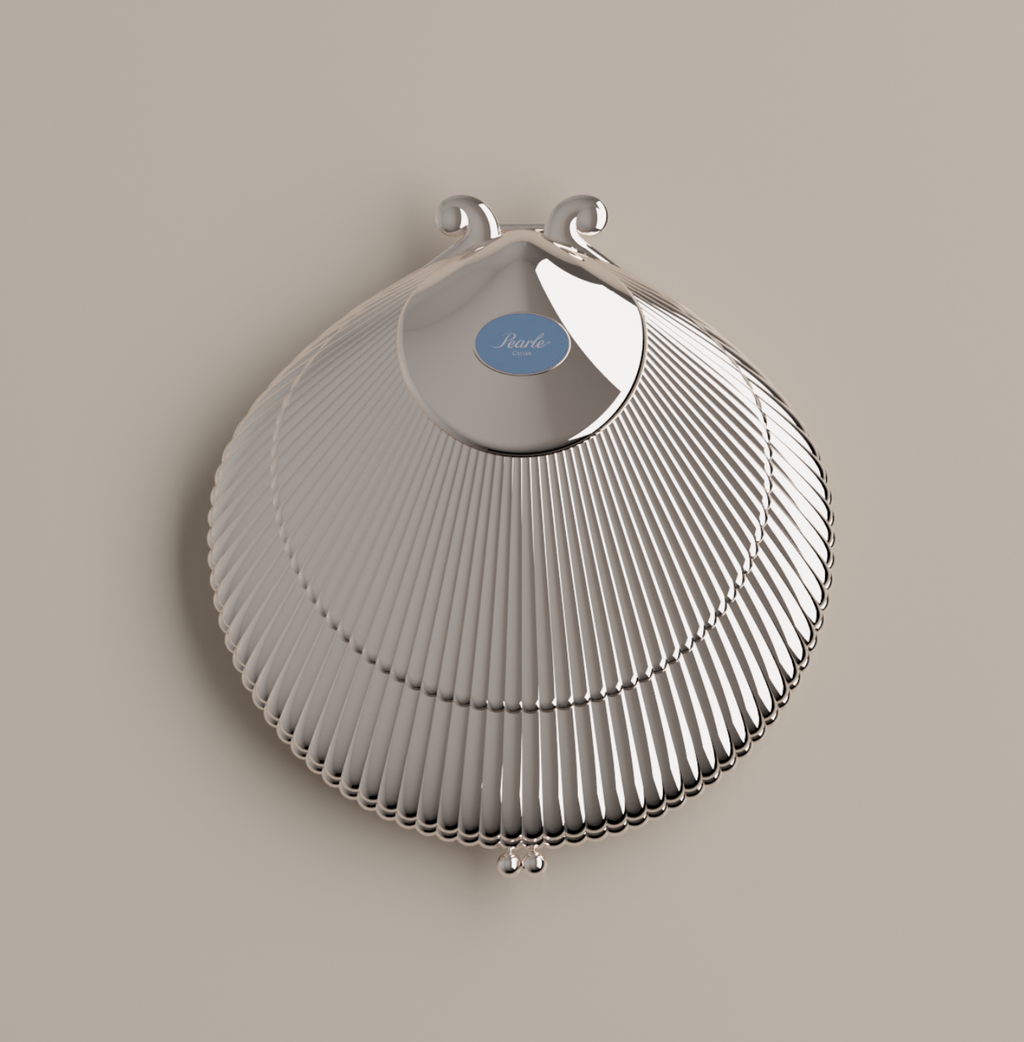 Silver shell-shaped caviar serving shell (top shell) with a blue label on a beige background